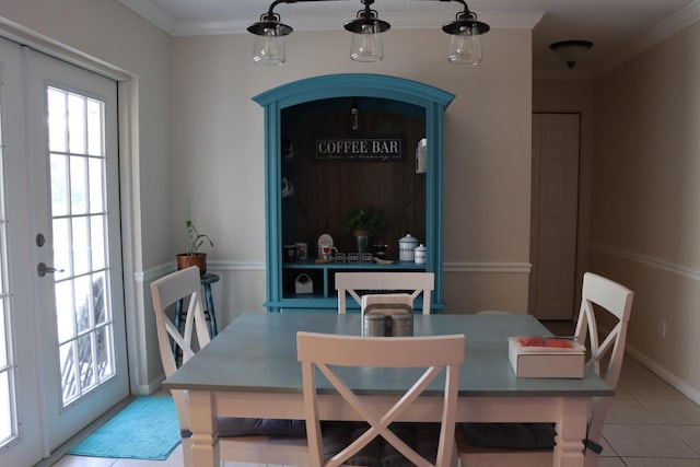 tiled dining room featuring ornamental molding and french doors