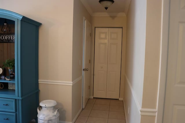 hallway featuring light tile patterned floors and ornamental molding