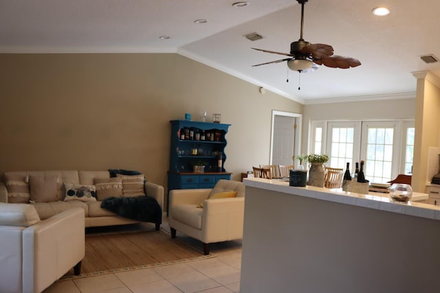 living room with french doors, ornamental molding, ceiling fan, light tile patterned floors, and lofted ceiling