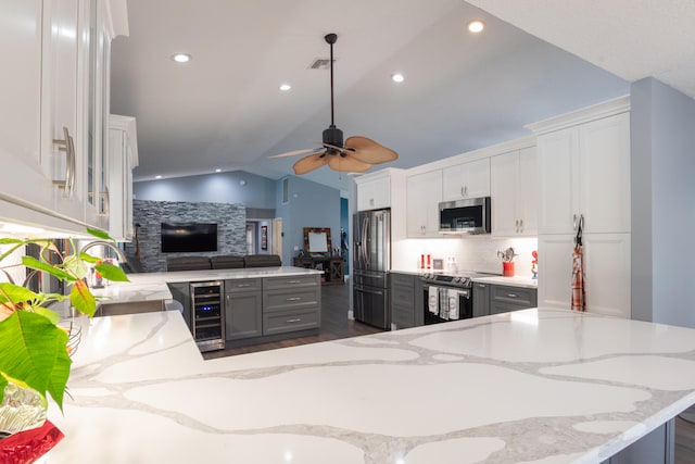 kitchen with wine cooler, lofted ceiling, dark wood-type flooring, and appliances with stainless steel finishes