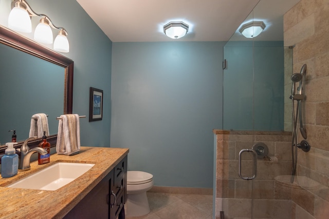 bathroom featuring vanity, tile patterned flooring, toilet, and walk in shower