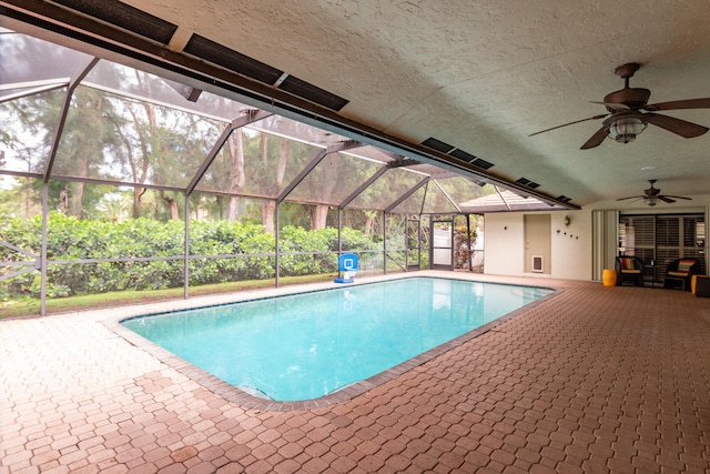 view of pool with ceiling fan, a patio area, and a lanai