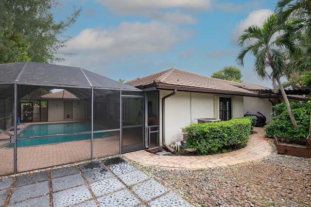 back of house featuring a patio area and glass enclosure