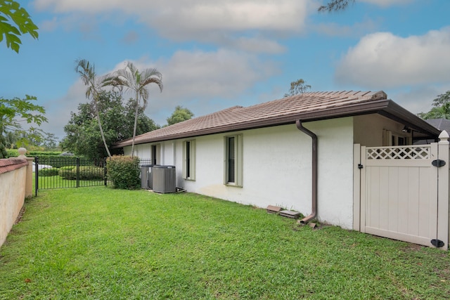 view of side of property with a yard and central air condition unit