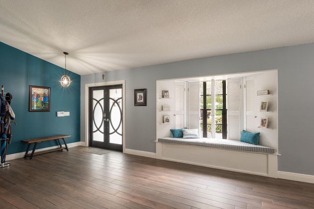 foyer entrance featuring dark wood-type flooring, a healthy amount of sunlight, and a textured ceiling