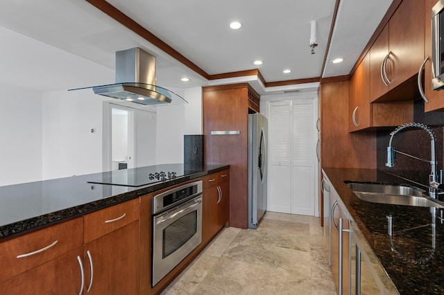 kitchen featuring decorative backsplash, stainless steel appliances, island exhaust hood, dark stone counters, and sink