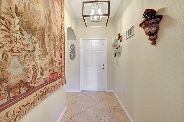 doorway to outside with a chandelier and light tile patterned floors