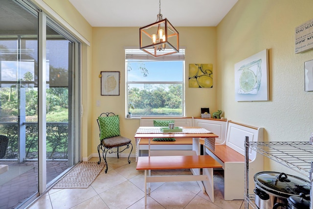 tiled dining area featuring a notable chandelier