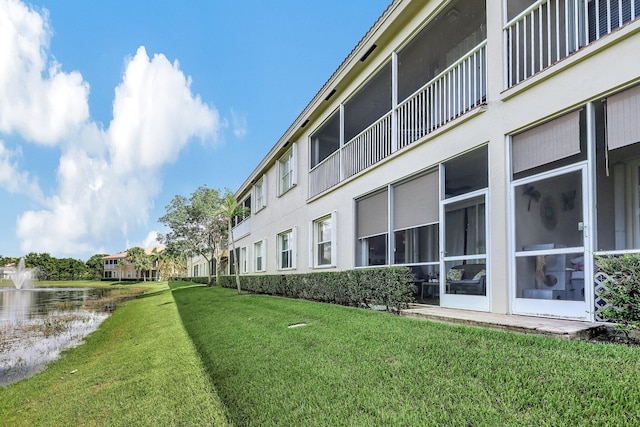 view of community featuring a lawn and a water view