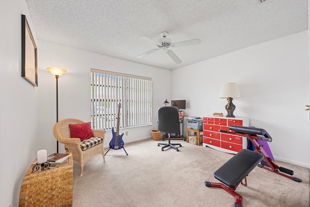 home office featuring carpet flooring, ceiling fan, and a textured ceiling