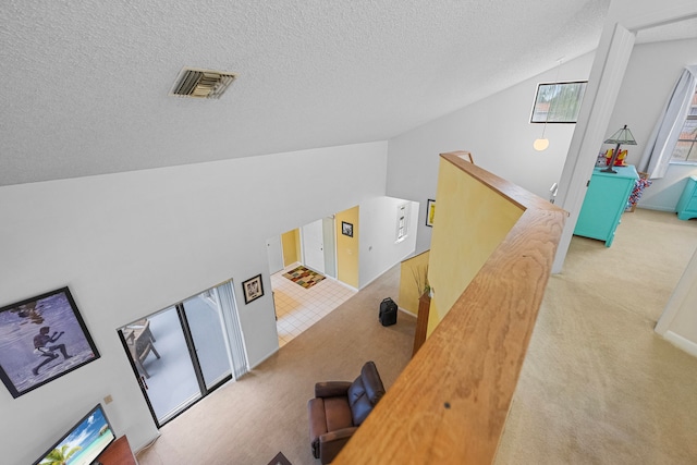 interior space with carpet floors, a textured ceiling, and vaulted ceiling