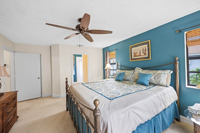 carpeted bedroom featuring ceiling fan and a textured ceiling