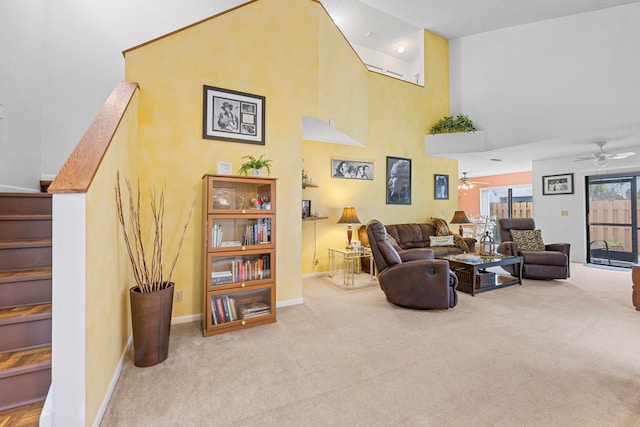 carpeted living room featuring ceiling fan and a towering ceiling