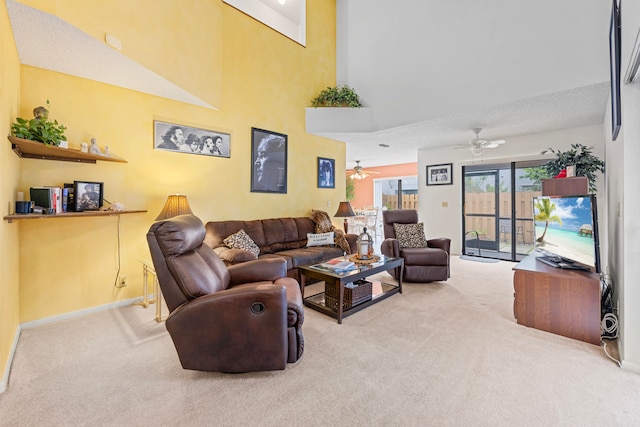 living room with carpet, ceiling fan, a towering ceiling, and a textured ceiling