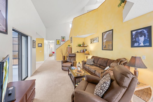 living room with high vaulted ceiling and light colored carpet