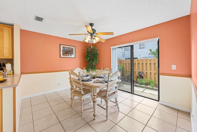 dining area featuring light tile patterned floors, a textured ceiling, and ceiling fan