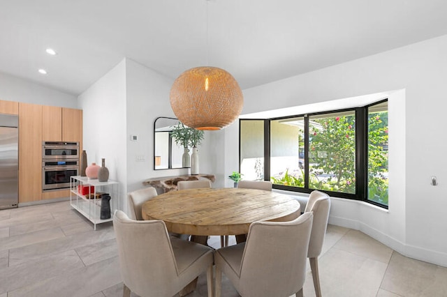 tiled dining space featuring lofted ceiling