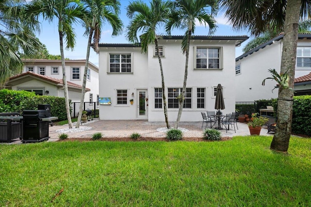 rear view of property with a lawn and a patio