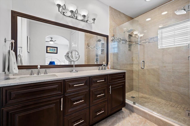 bathroom featuring a shower with shower door, vanity, and ceiling fan