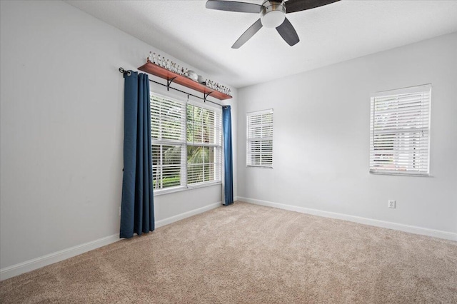 carpeted spare room with ceiling fan