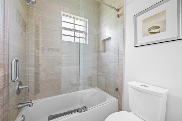 bathroom featuring shower / bath combination with glass door and toilet