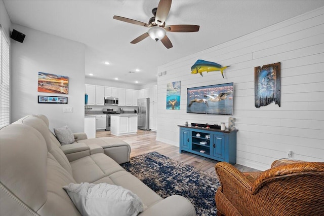 living room featuring ceiling fan and light hardwood / wood-style flooring