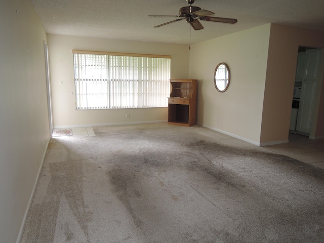 unfurnished living room with light carpet, ceiling fan, and a textured ceiling