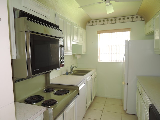 kitchen featuring lofted ceiling, white appliances, white cabinetry, and sink