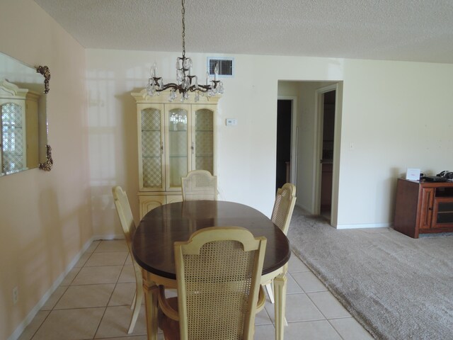 408 Sandpiper Dr Unit C, Fort Pierce, FL 34982 - dining room featuring visible vents, baseboards, a textured ceiling, light tile patterned floors, and a notable chandelier