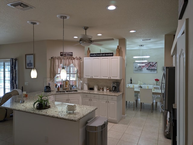 kitchen with white cabinetry, sink, ceiling fan, backsplash, and pendant lighting