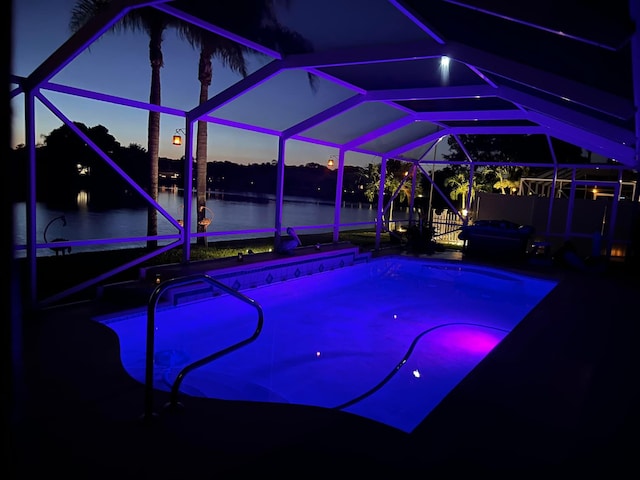 pool at dusk featuring a water view and glass enclosure