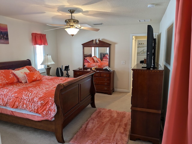 bedroom featuring a textured ceiling, ceiling fan, and light carpet