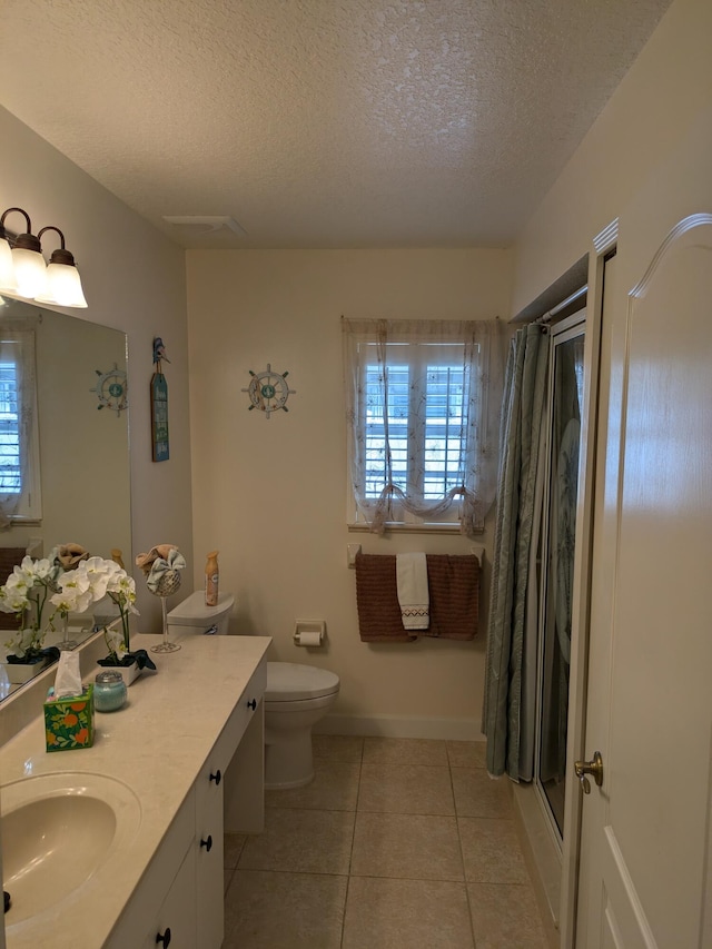 bathroom featuring tile patterned floors, a shower, a textured ceiling, toilet, and vanity