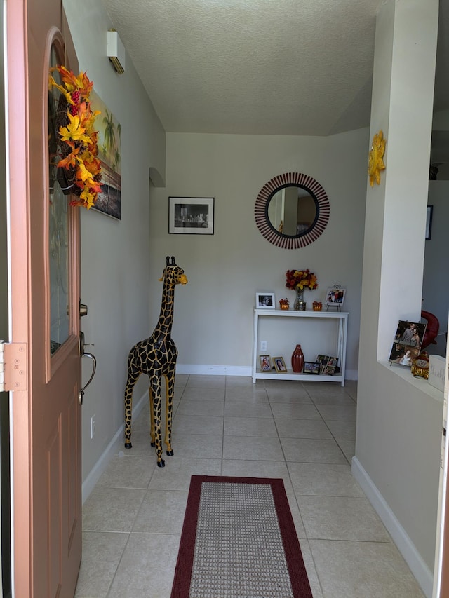 tiled foyer entrance featuring a textured ceiling