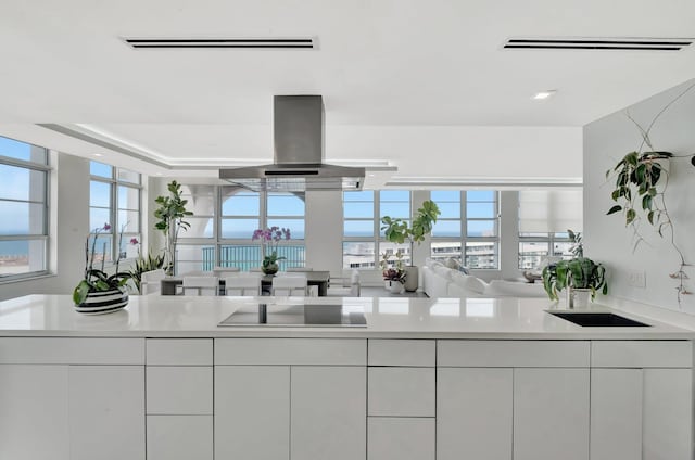 kitchen with white cabinetry, light countertops, modern cabinets, and island range hood