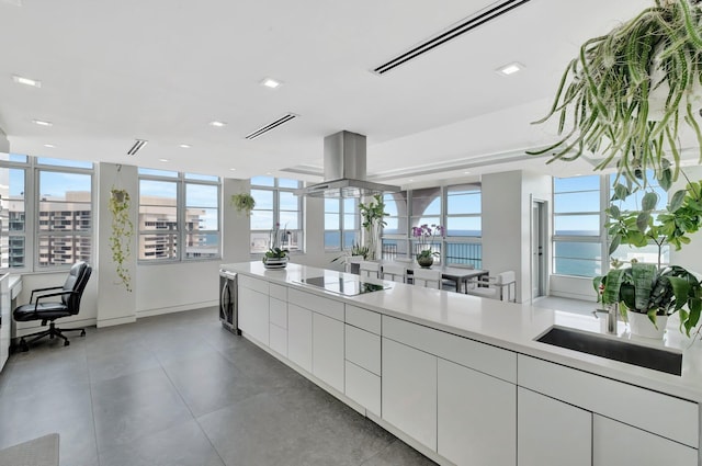kitchen featuring wine cooler, light countertops, island range hood, white cabinets, and black electric cooktop