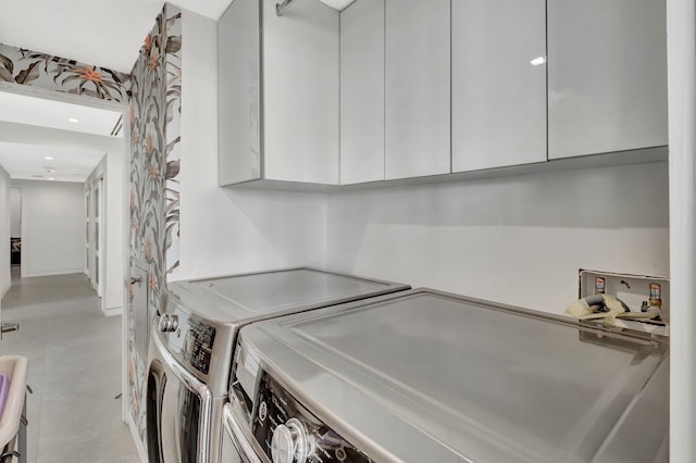 washroom with cabinet space and washer and clothes dryer