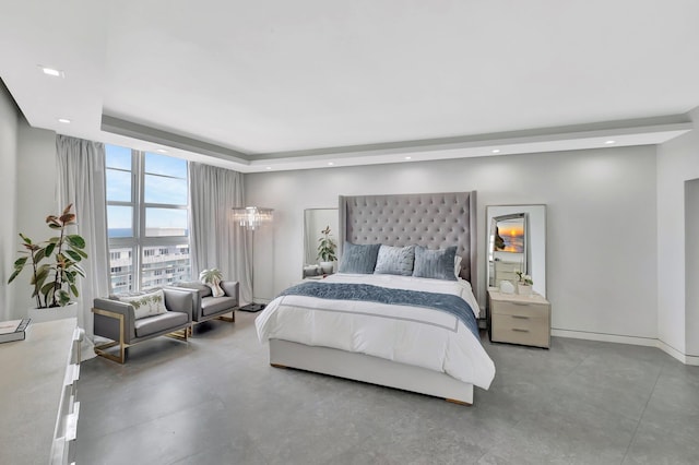 bedroom featuring a tray ceiling, recessed lighting, baseboards, and expansive windows