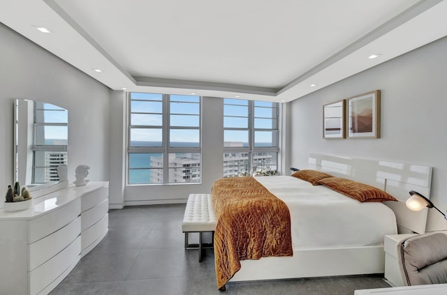 bedroom featuring recessed lighting, multiple windows, and a tray ceiling