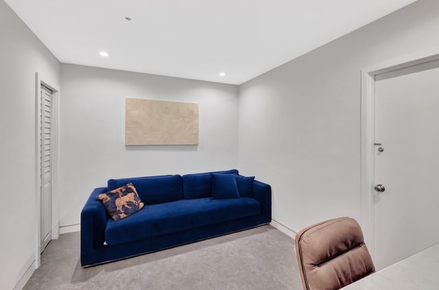 living room with recessed lighting, concrete floors, and baseboards