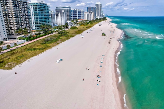 drone / aerial view with a city view, a beach view, and a water view