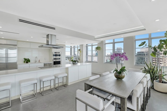 dining space featuring plenty of natural light, recessed lighting, and a tray ceiling