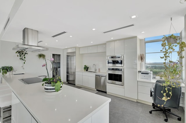kitchen featuring visible vents, appliances with stainless steel finishes, white cabinetry, modern cabinets, and island range hood