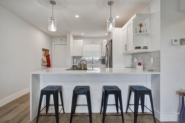 kitchen with dark hardwood / wood-style flooring, pendant lighting, built in refrigerator, and white cabinets