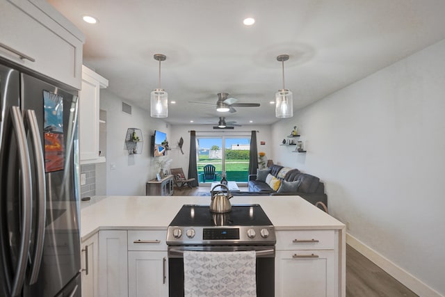 kitchen with ceiling fan, white cabinets, kitchen peninsula, dark wood-type flooring, and stainless steel appliances