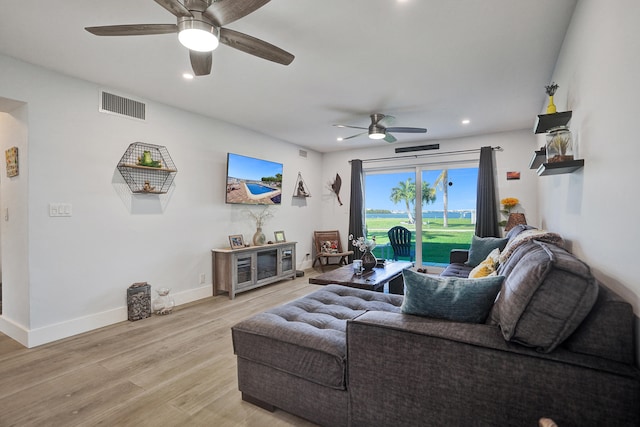 living room with ceiling fan and light hardwood / wood-style flooring