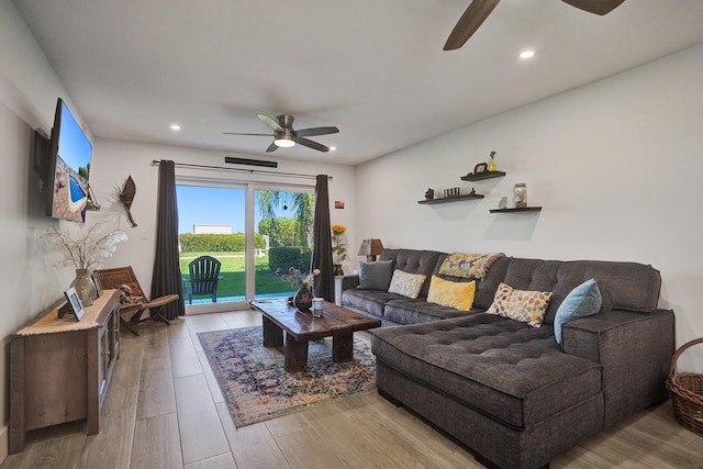 living room featuring ceiling fan and light wood-type flooring