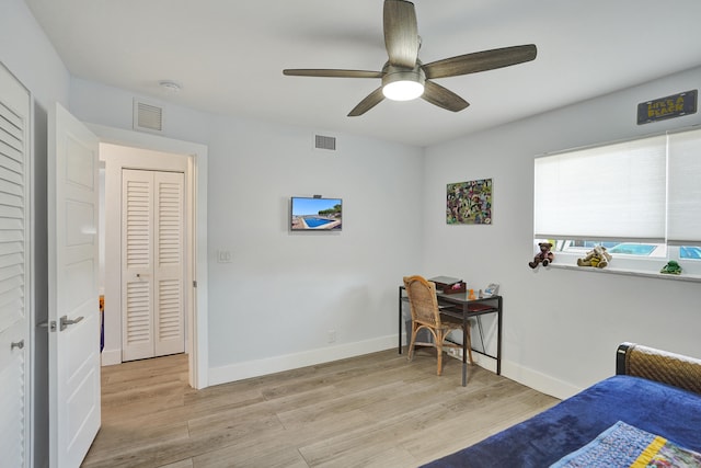 bedroom with light hardwood / wood-style floors, ceiling fan, and a closet