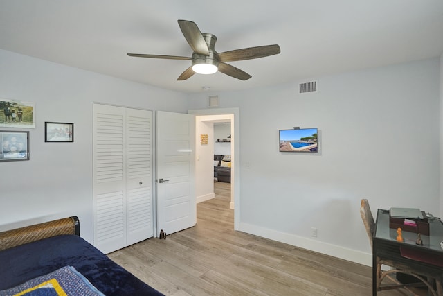 bedroom with a closet, light wood-type flooring, and ceiling fan