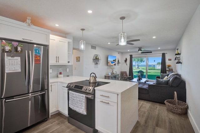 kitchen with stainless steel appliances, white cabinetry, kitchen peninsula, and dark wood-type flooring